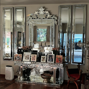 Luxury Venetian mirrored console table with ornate framed mirror and flanking tall mirrors in a lavish entryway.