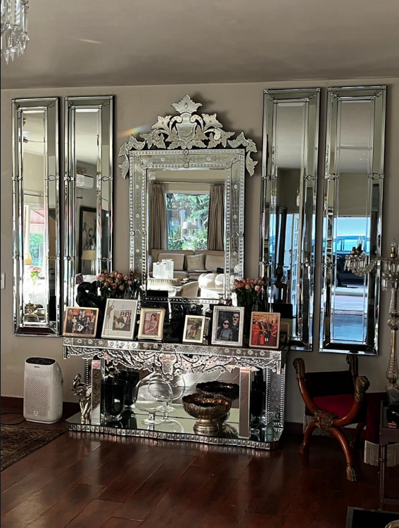 Luxury Venetian mirrored console table with ornate framed mirror and flanking tall mirrors in a lavish entryway.